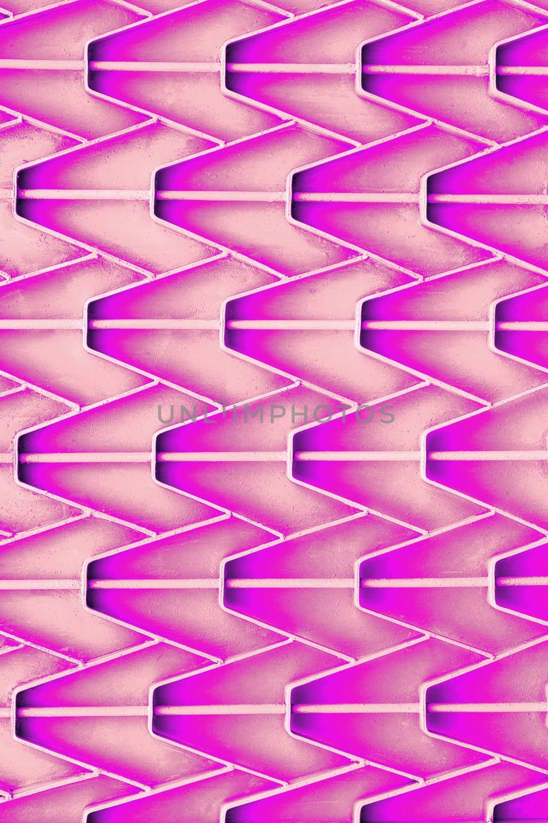 Patterned metal fence with outdated bright pink paint. Abstract texture background. Vertical format. by Sergii