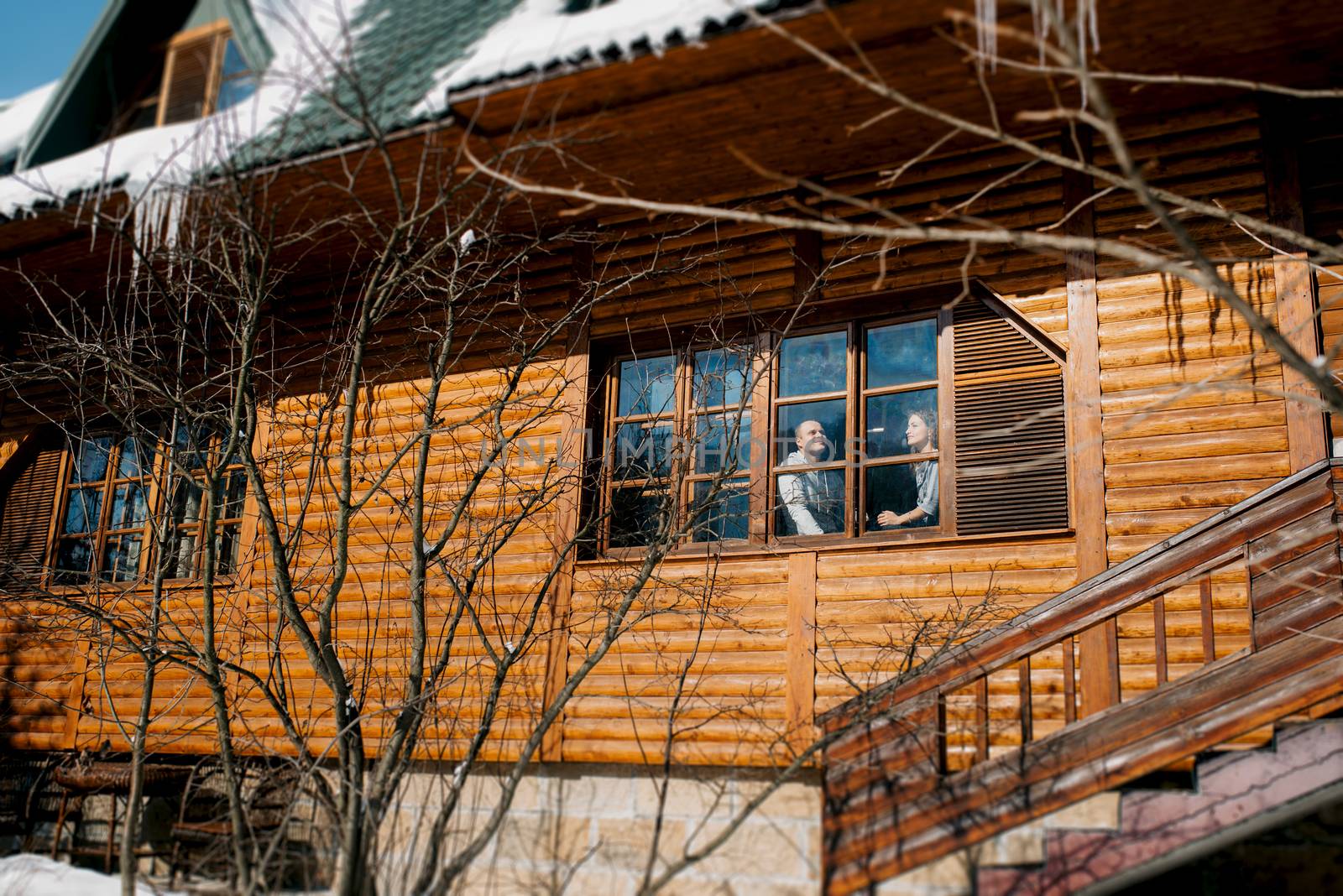 guy and girl in the house near the window overlooking a snowy landscape