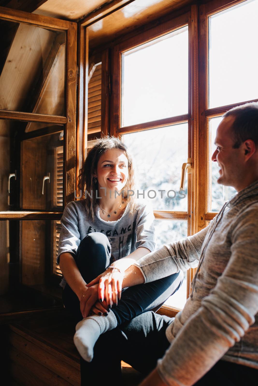 guy and girl in the house near the window overlooking a snowy landscape