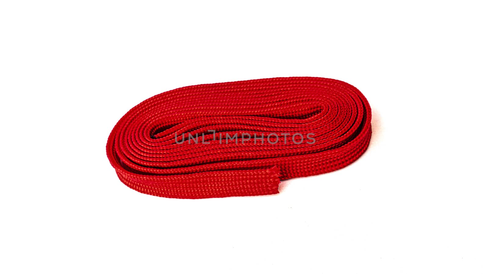 Red rope on white background. Fabric rope in red color folded in a coil.