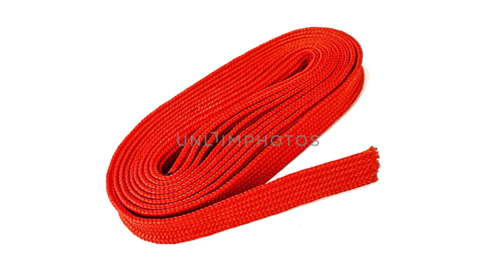 Red rope on white background. Fabric rope in red color folded in a coil.