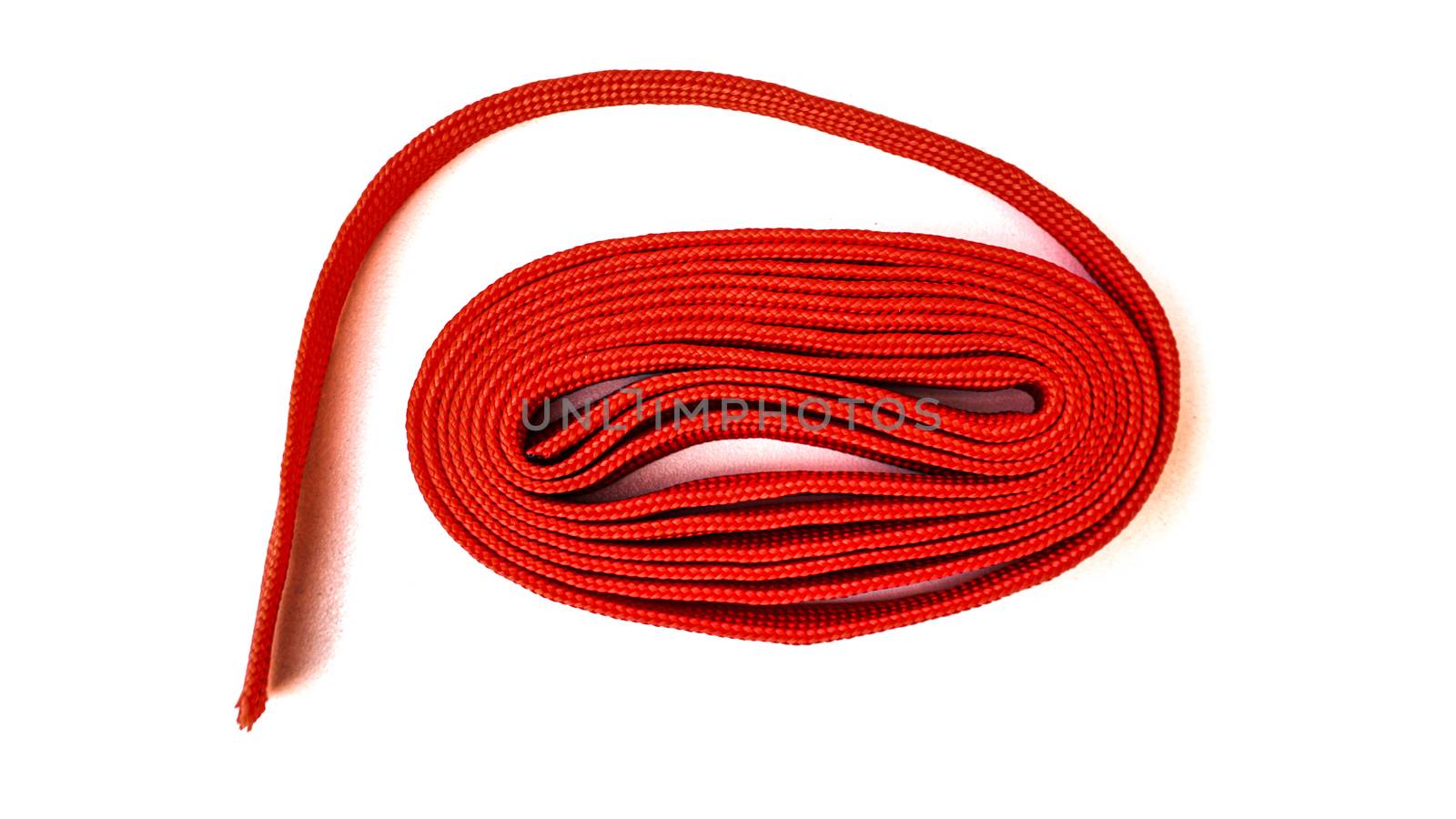 Red rope on white background. Fabric rope in red color folded in by sonandonures