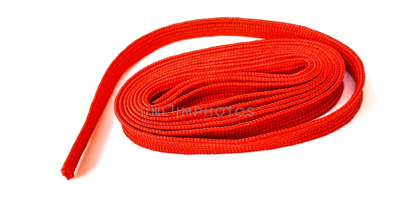 Red rope on white background. Fabric rope in red color folded in by sonandonures