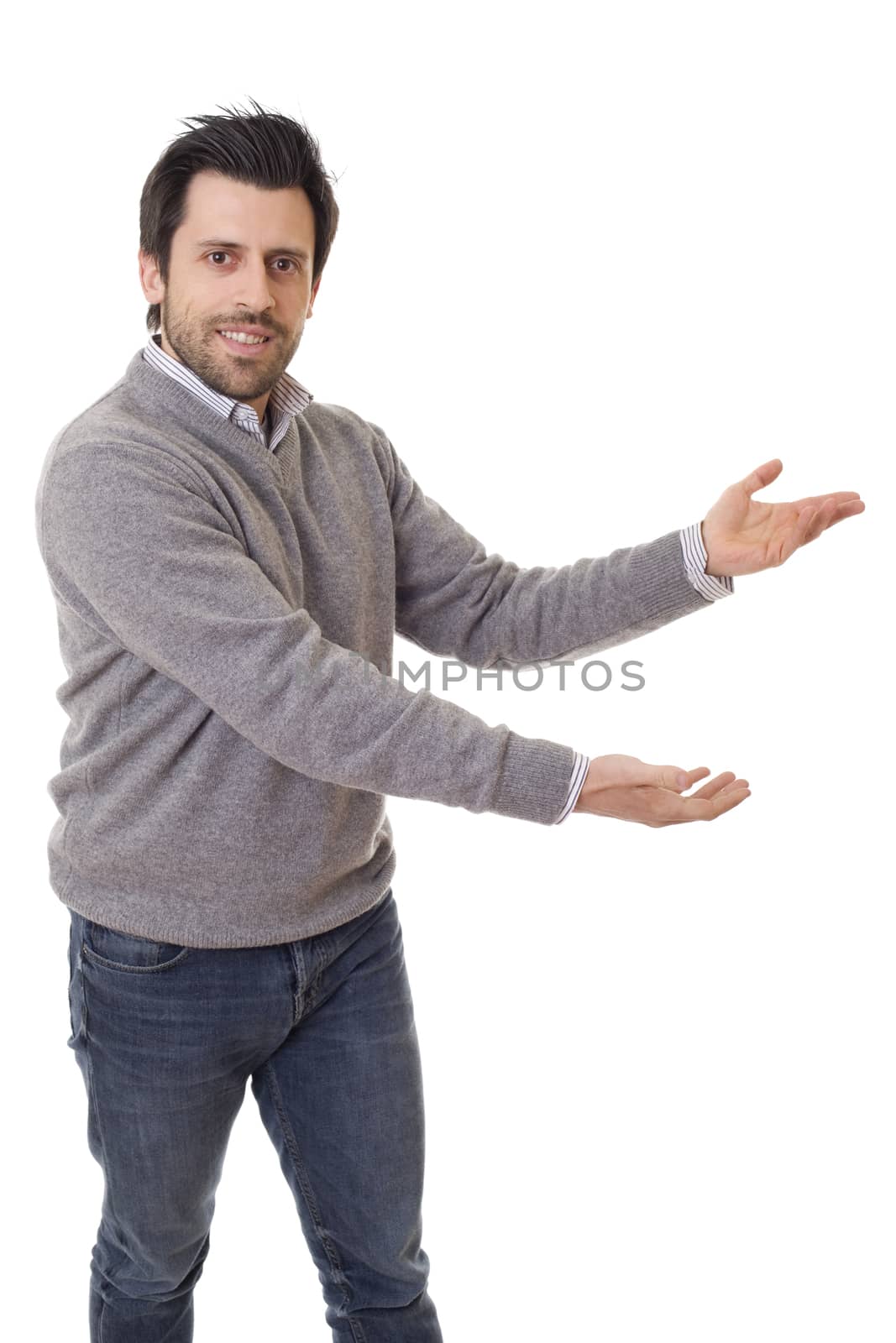 friendly young man pointing to his side and looking into the camera. isolated on white background