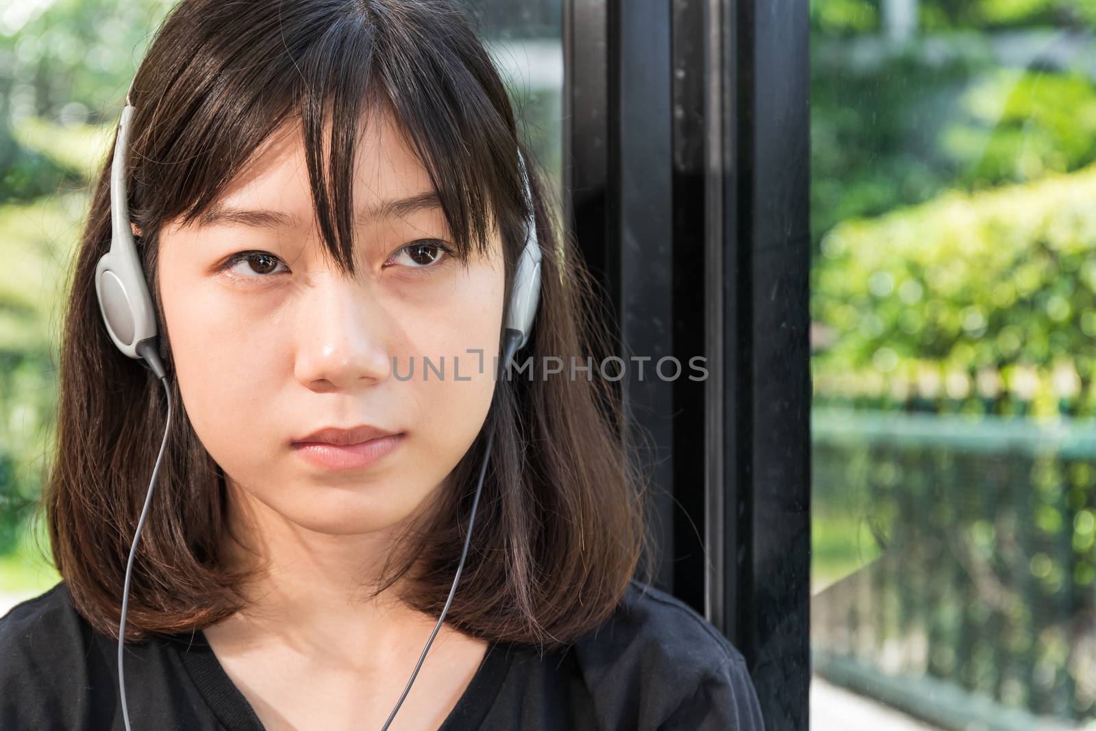 Teenage female with headphones and listening to music from mobile phone  at home