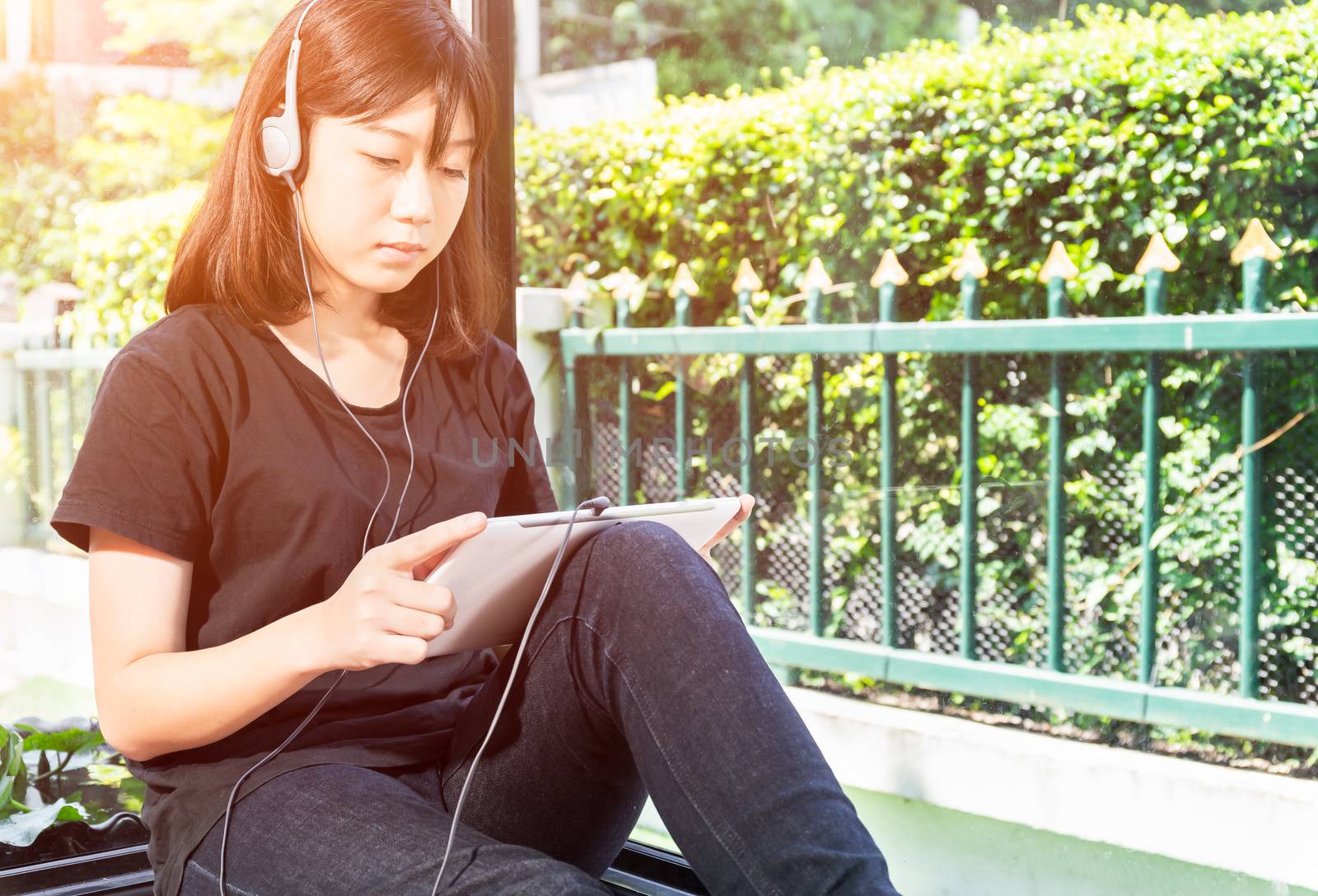 Happy teenage female  listening to the music from a digital tablet in room at home