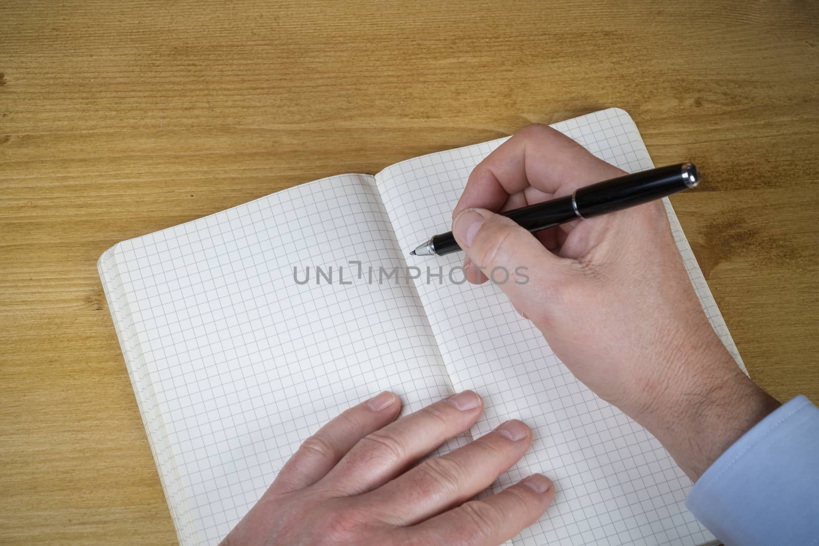 a man writing in a squared notebook