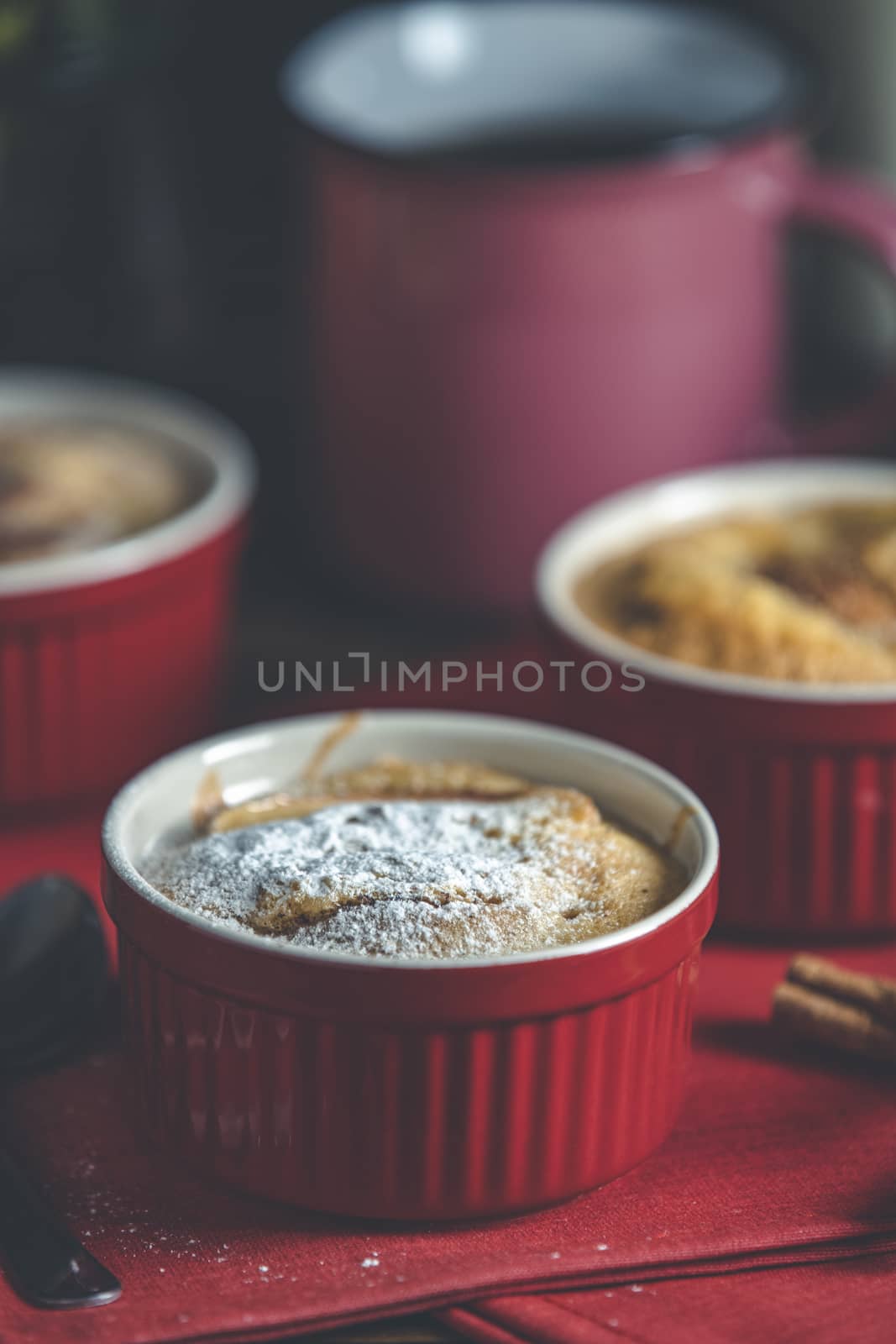 Apple pie in ceramic baking molds ramekin on dark red napkin. Cl by ArtSvitlyna