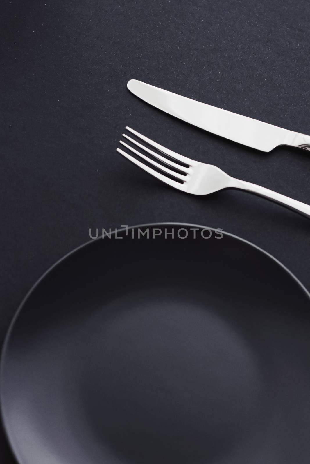 Empty plates and silverware on black background, premium tableware for holiday dinner, minimalistic design and diet concept