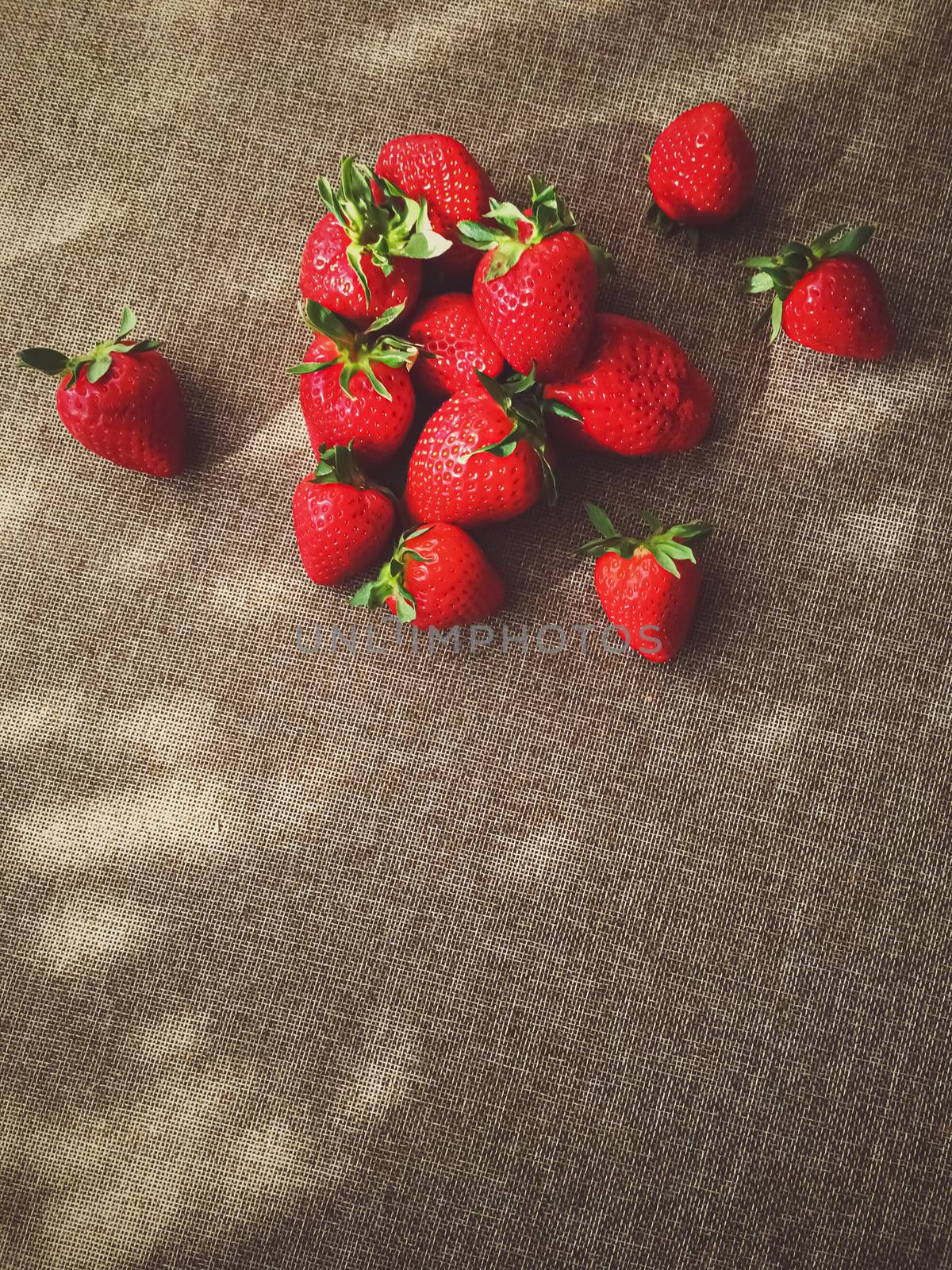 Organic strawberries on rustic linen background by Anneleven