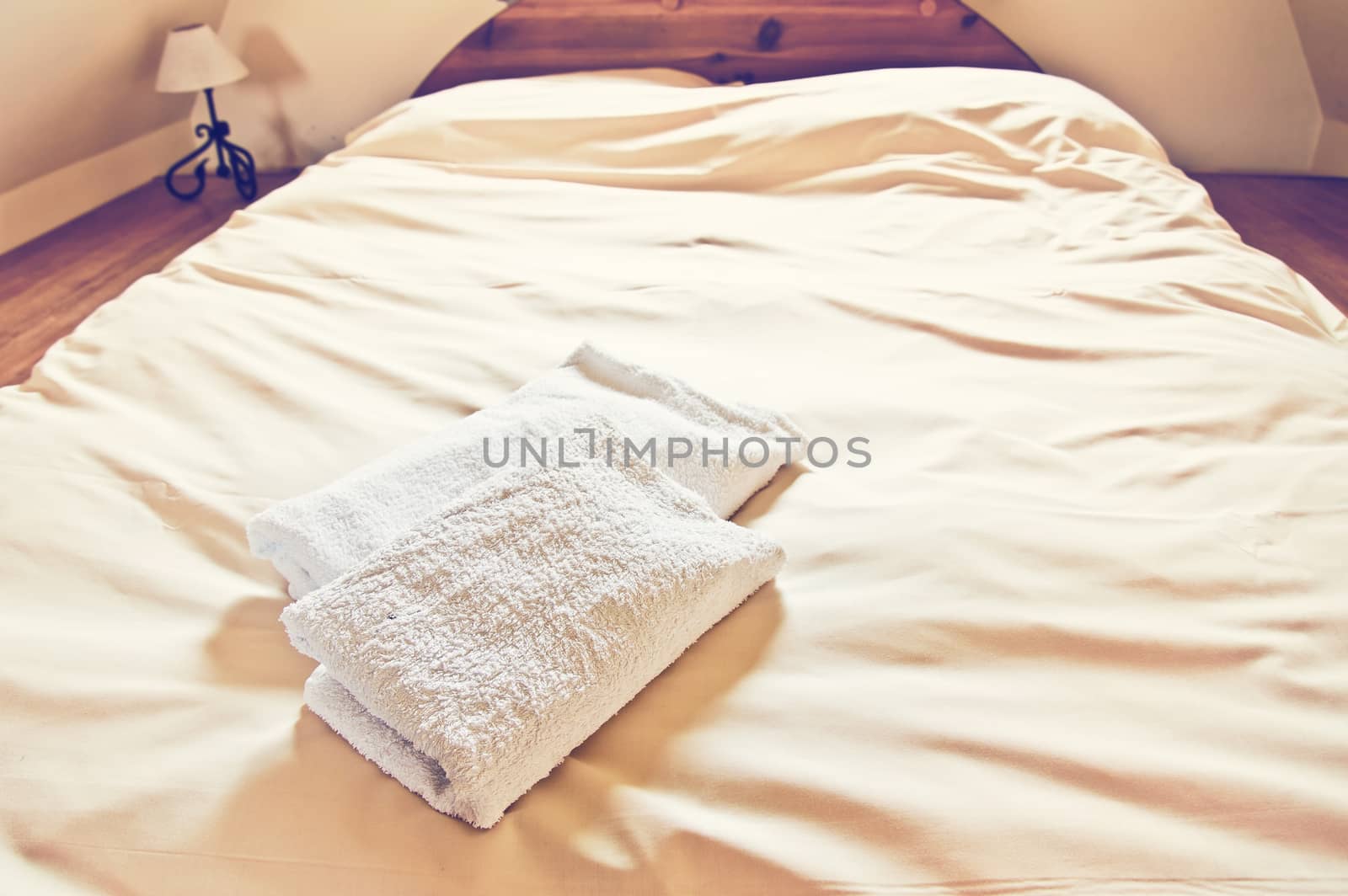 Towels on the white fresh bedsheet. Everyday objects in house concept. Vintage colors.