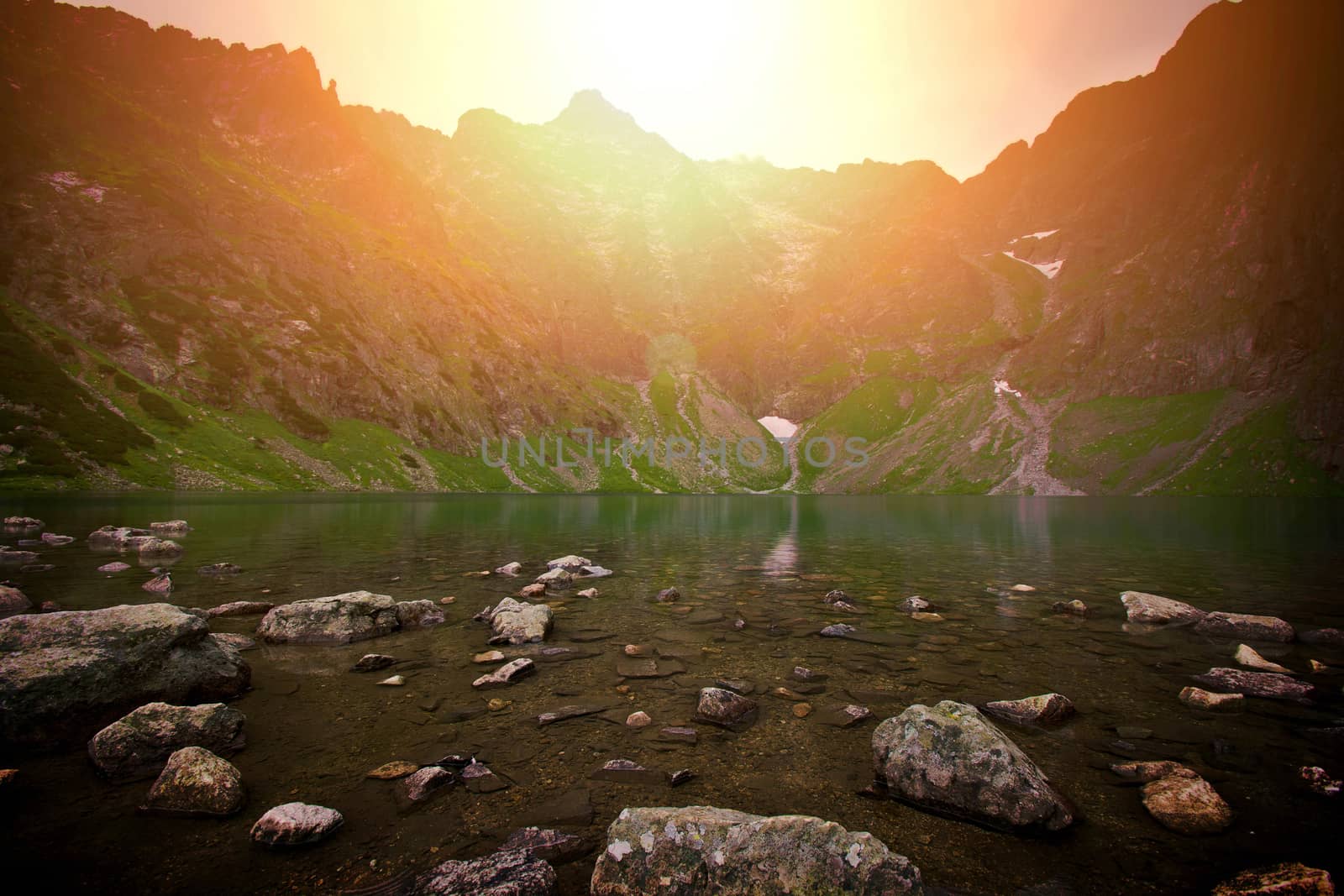 Sunset over lake in mountains. Nature concept.