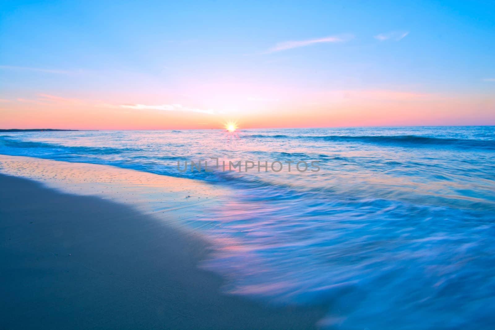 Sea waves and sunset. Blue sea landscape. Motion blur abstract picture.