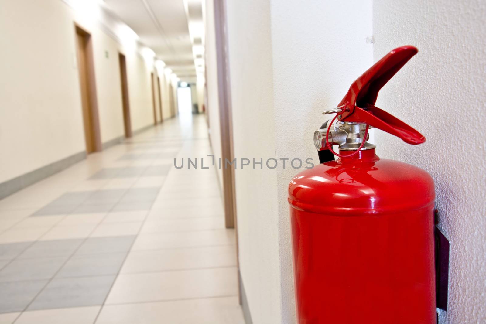 Red Fire extinguisher in the corridor. Safety concept.