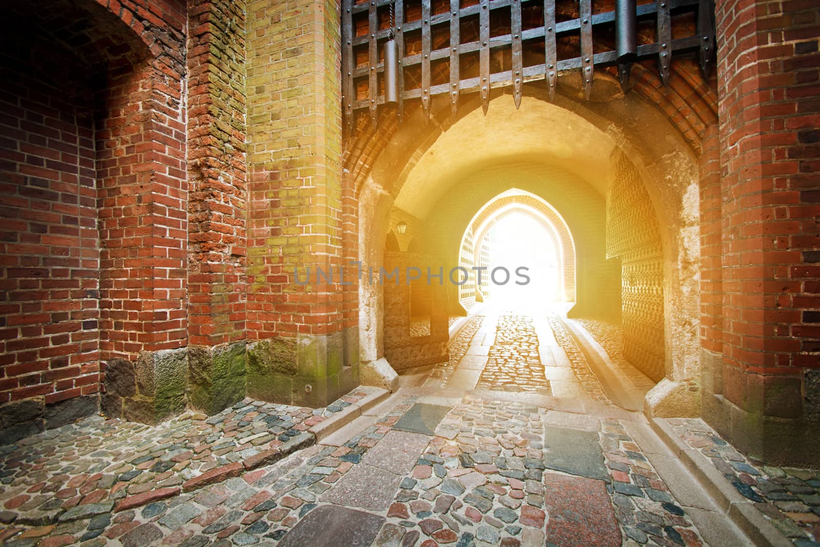 Old medieval entrance gate bathed in the light of the sun.