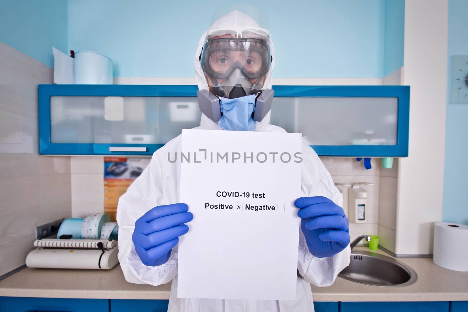 Doctor in protective suit uniform and mask holds coronovirus test results. by satariel