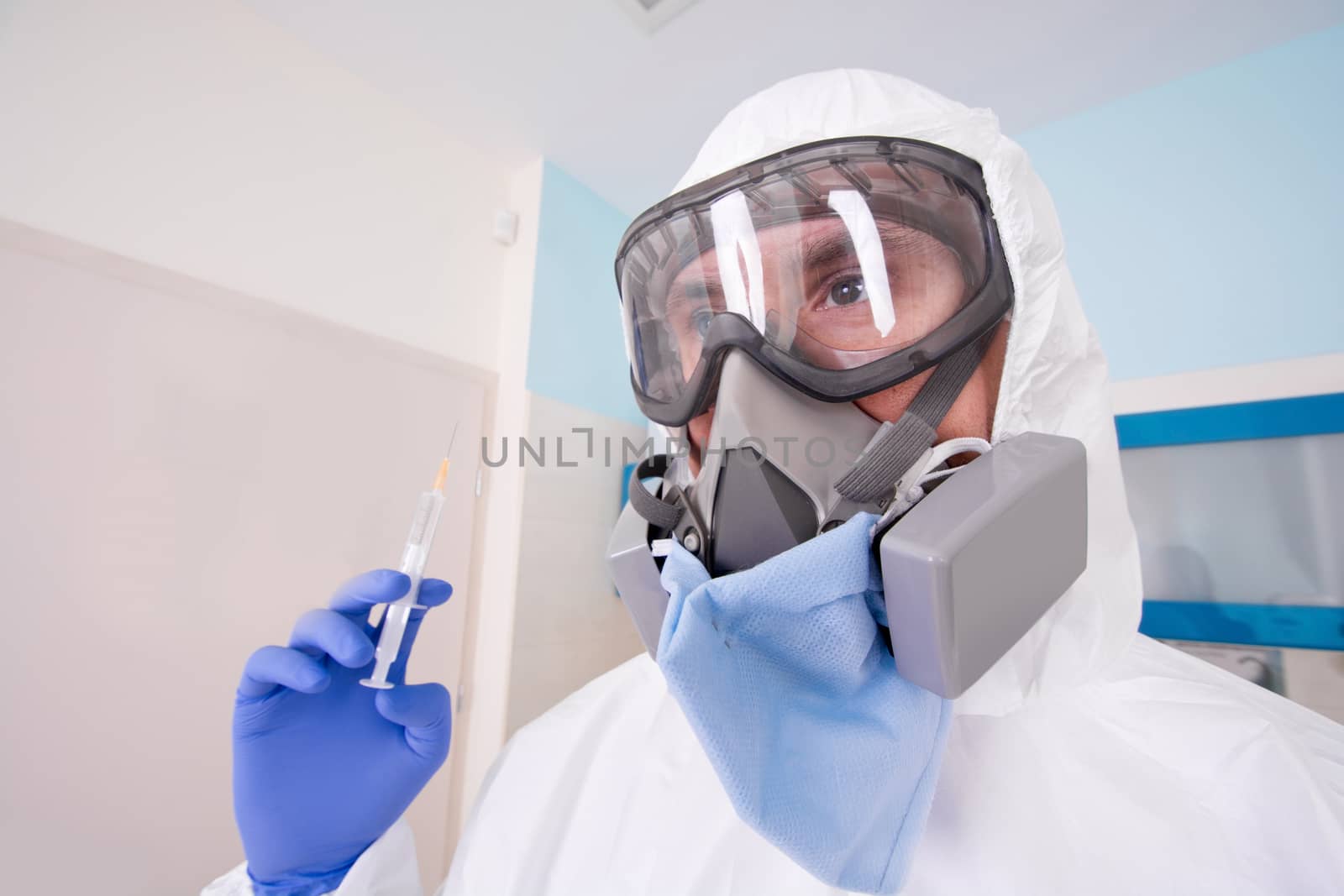 Doctor in protective suit uniform and mask holds injection syringe with vaccine. Coronavirus outbreak. Covid-19 concept.