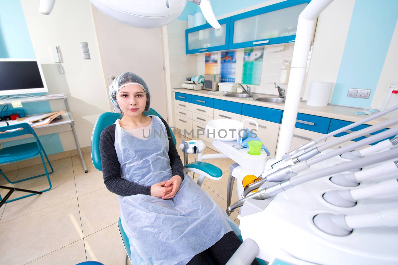 Female patient waiting for dental treatment in a dental chair. Dental Hygiene and Health conceptual image.