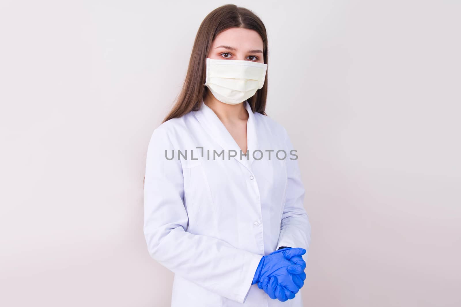 Female doctor wearing protection face mask and gloves. by satariel