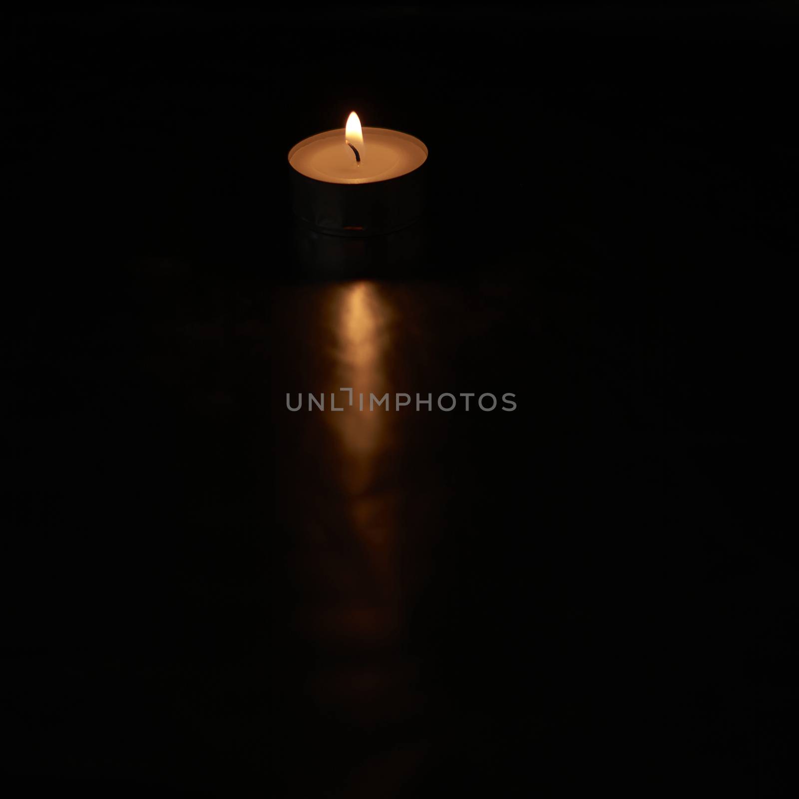 Small burning candle on black background by raul_ruiz