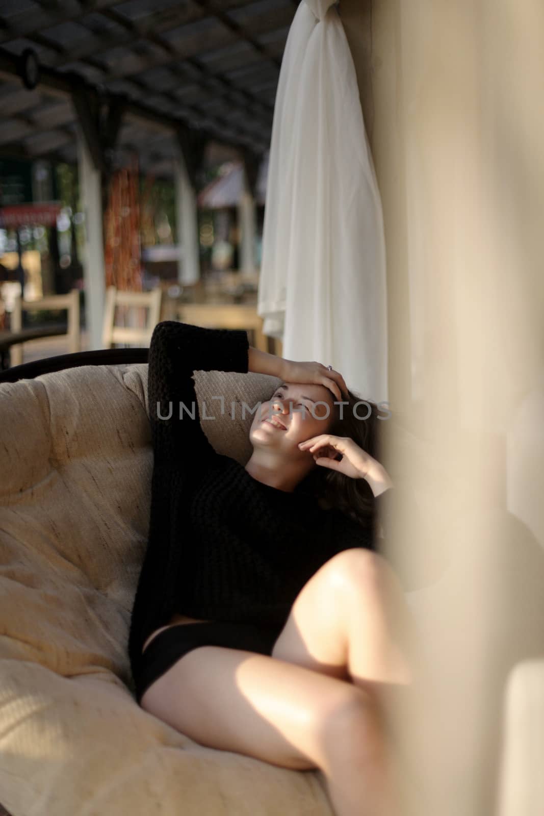 portrait of young girl in black jacket sweater at sunset, summer interior