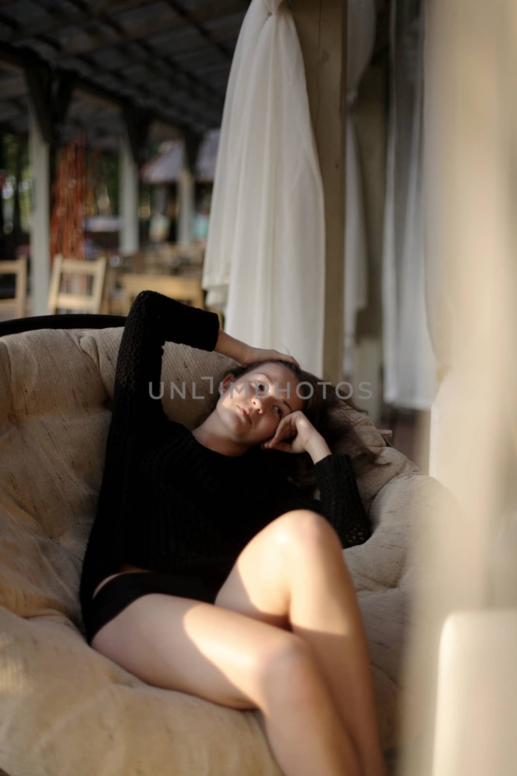 portrait of young girl in black jacket sweater at sunset, summer interior