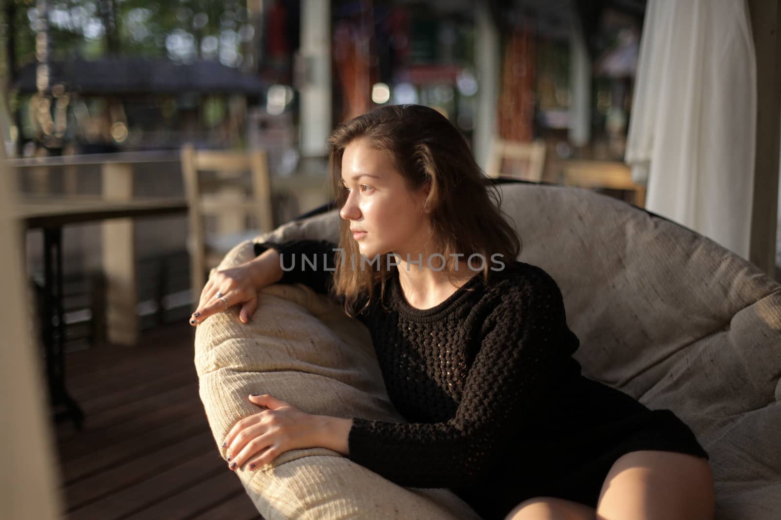 portrait of young girl in black jacket sweater at sunset, summer interior