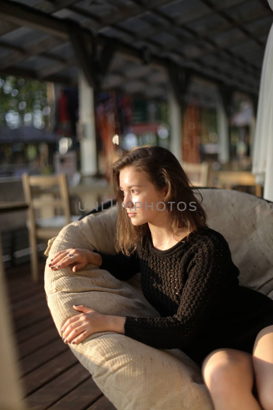 portrait of young girl in black jacket sweater at sunset, summer interior