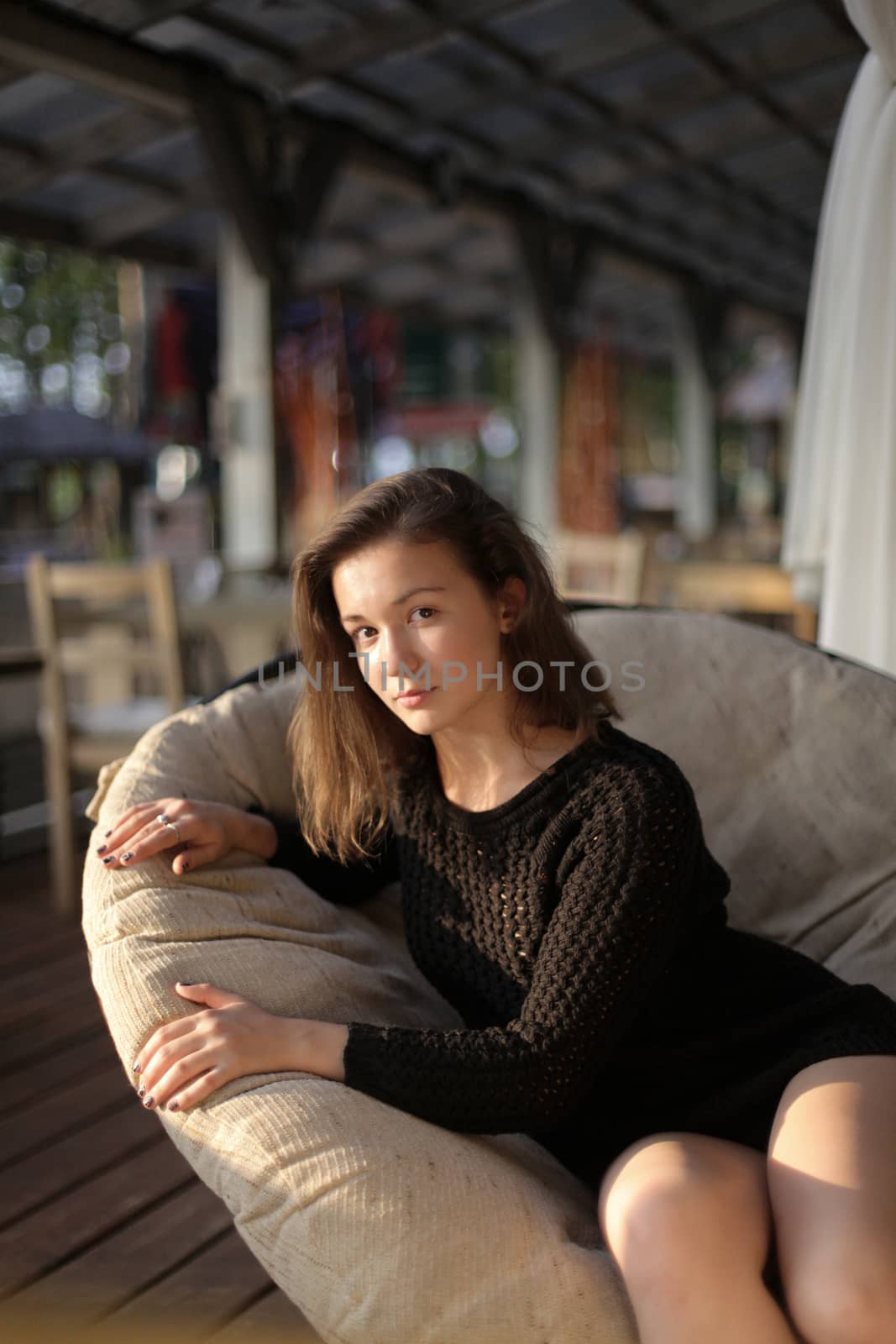 portrait of young girl in black jacket sweater at sunset, summer interior