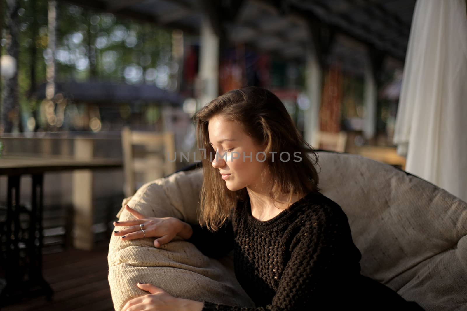 portrait of young girl in black jacket sweater at sunset, summer interior