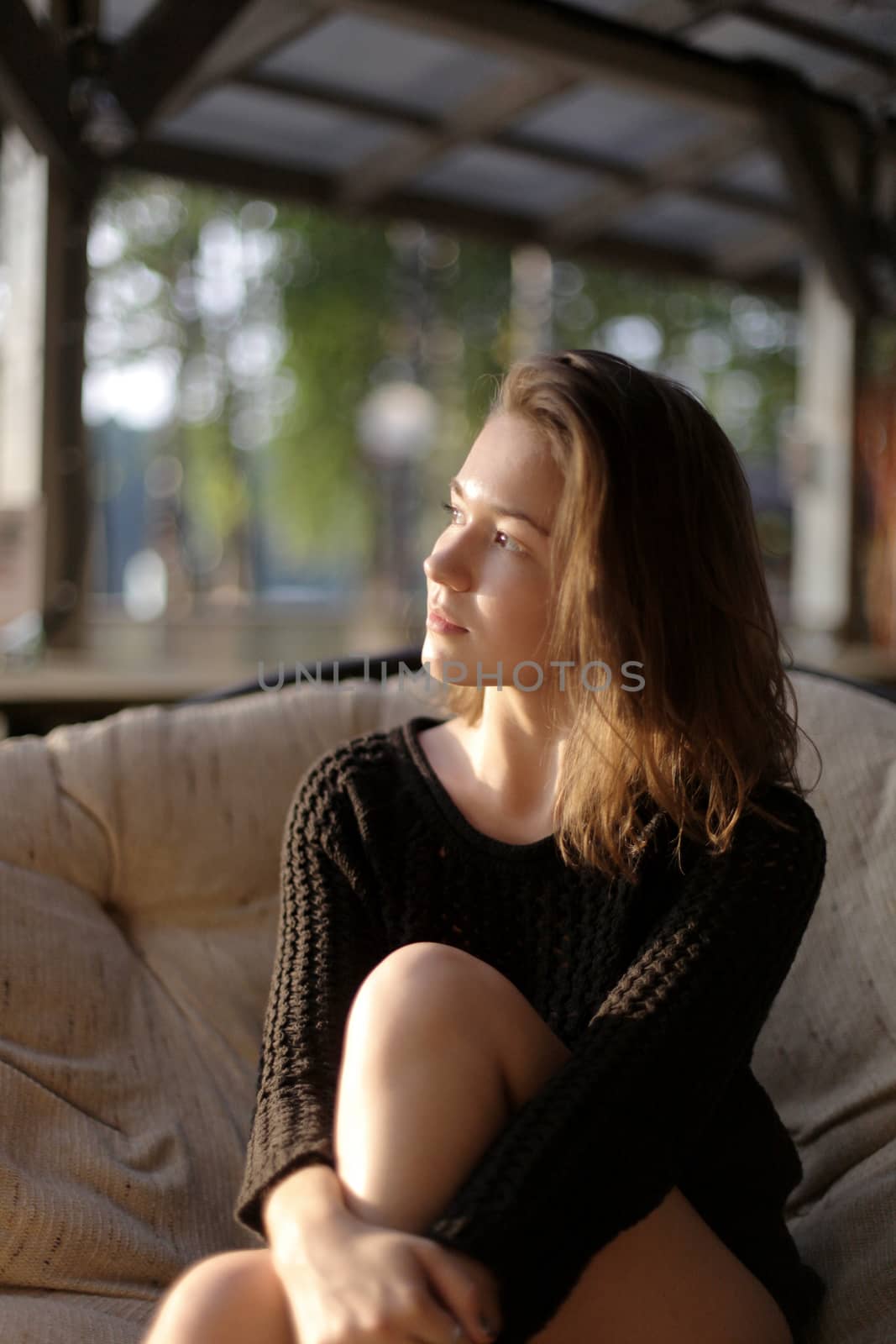 portrait of young girl in black jacket sweater at sunset, summer interior