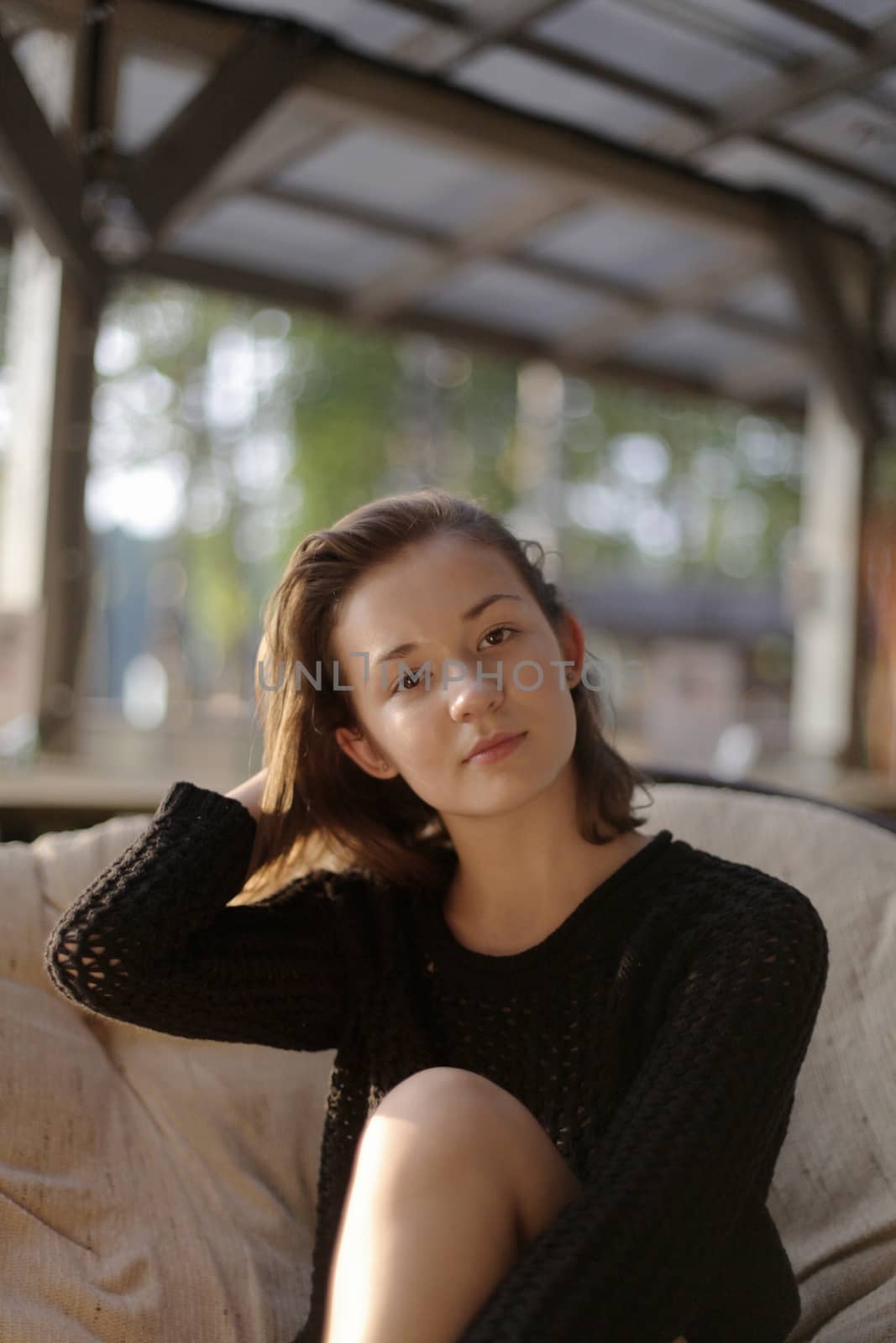 portrait of young girl in black jacket sweater at sunset, summer interior