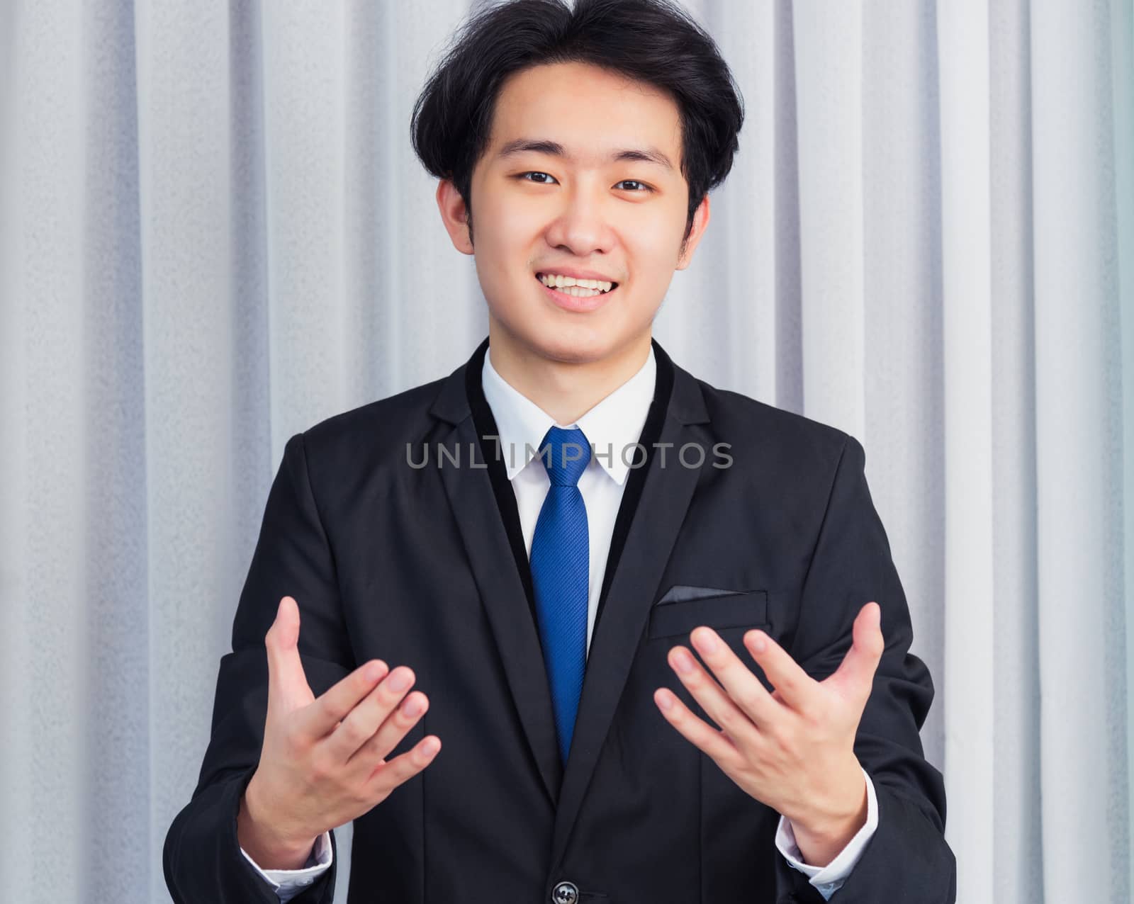 Work from home, Close up face of Asian young businessman wear suit video conference call or facetime he looking to camera raises hands to explain about his job to the team at the home office