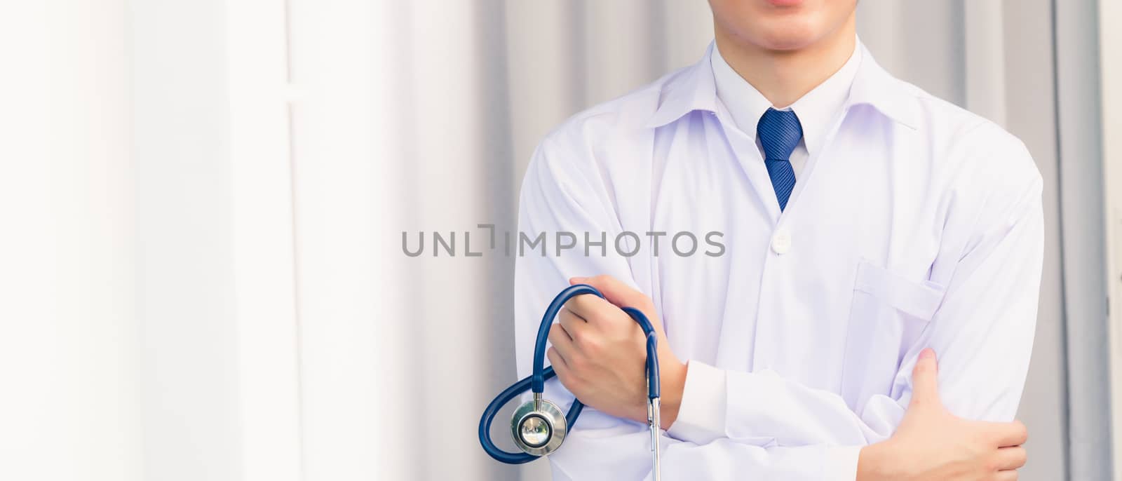 Portrait doctor man smiling crossed arm hold stethoscope by Sorapop