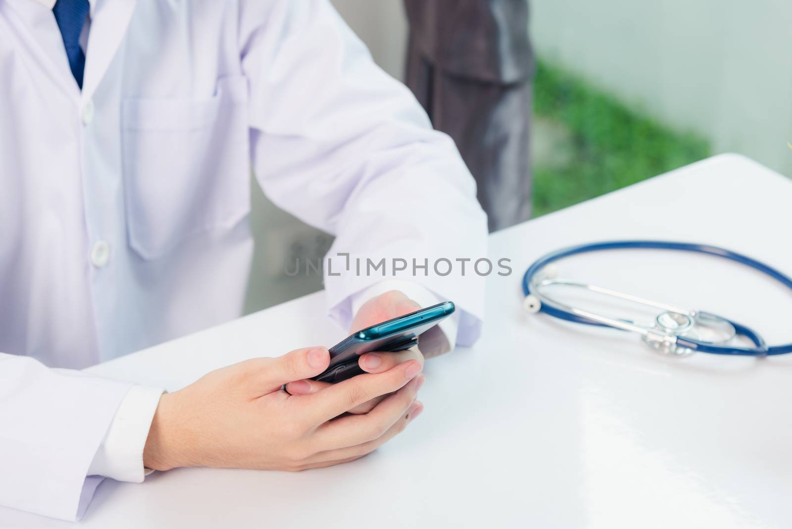 Doctor woman smiling using working with smart mobile phone by Sorapop