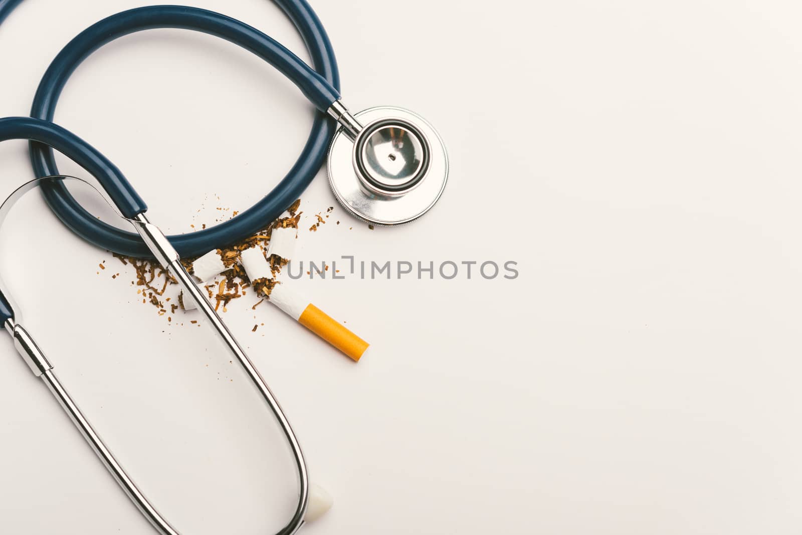 31 May of World No Tobacco Day, no smoking, close up of broken pile cigarette or tobacco and doctor stethoscope on white background with copy space, and Warning lung health concept