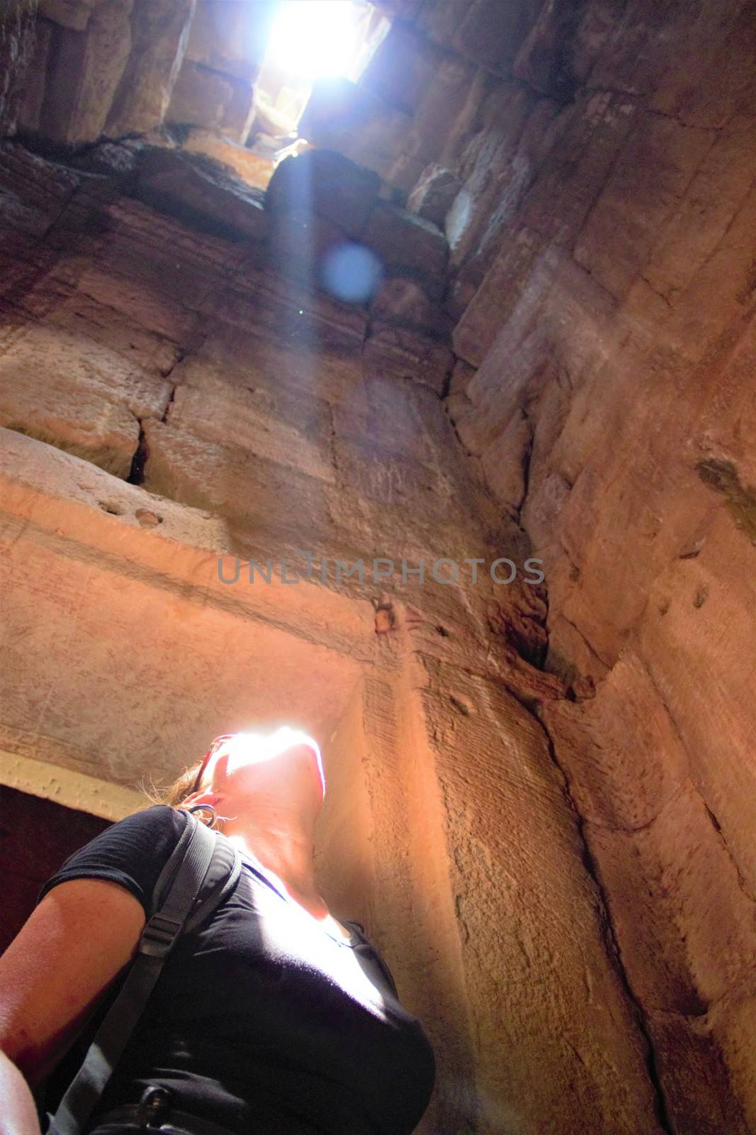 girl in temple looking up and seeing the light becoming religious finding god