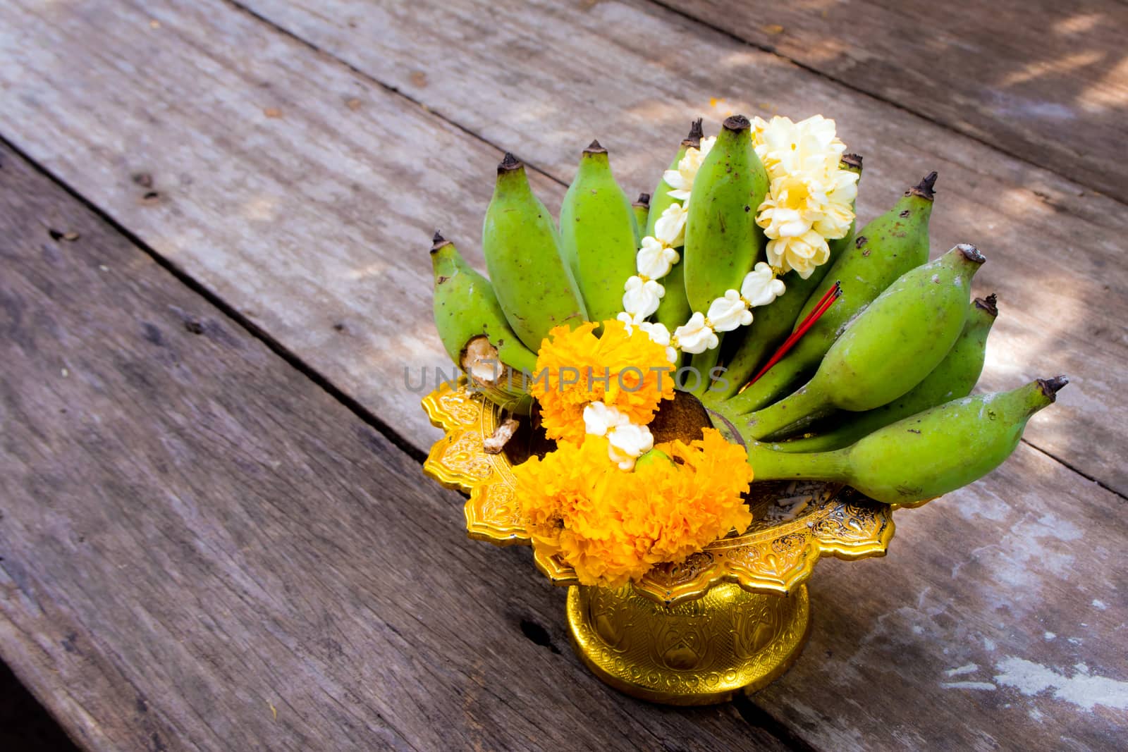 Flower garlands and banana on pedestal tray