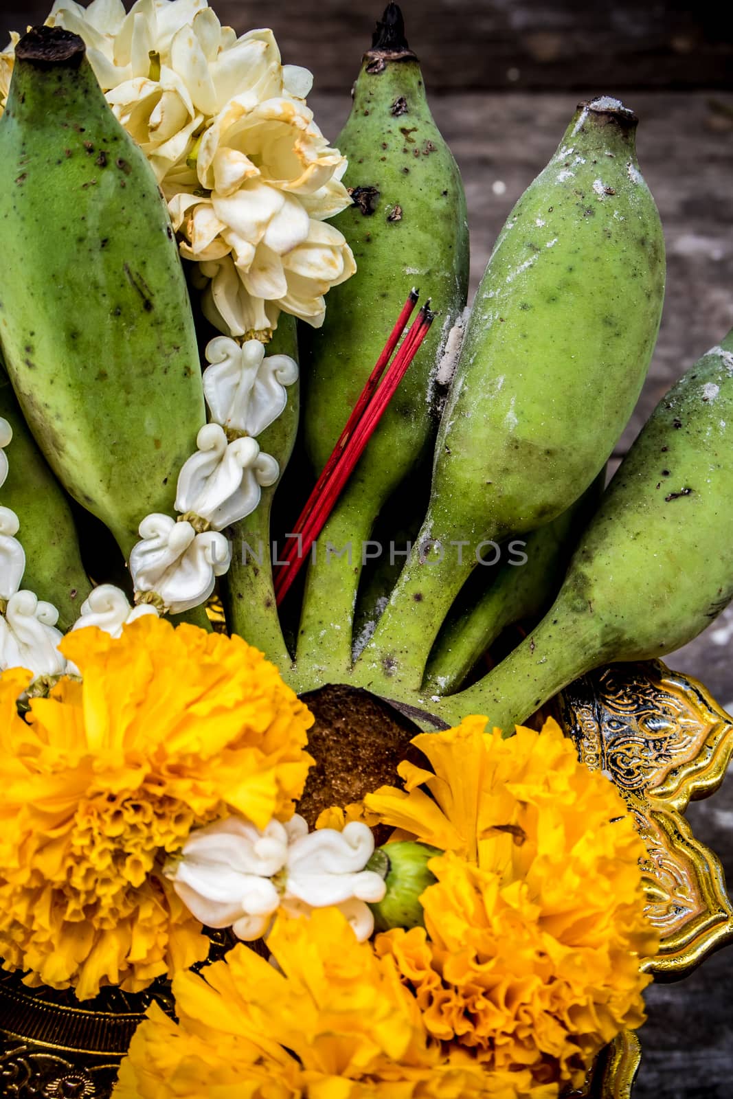 Banana and flower garland on pedestal tray by Satakorn