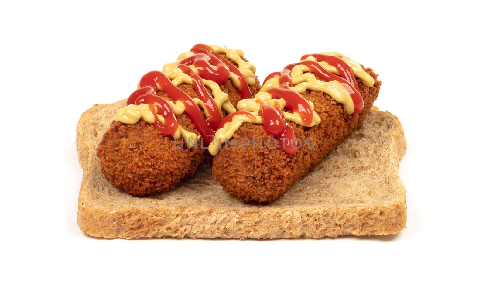 Brown crusty dutch kroket with mustard topping isolated, on a piece of bread, on a white background