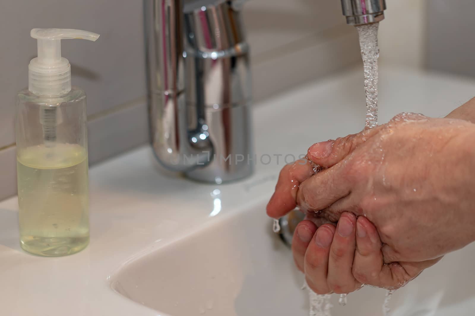 Man washing hands with soap and lathering suds. Protect against the coronavirus. by bonilook