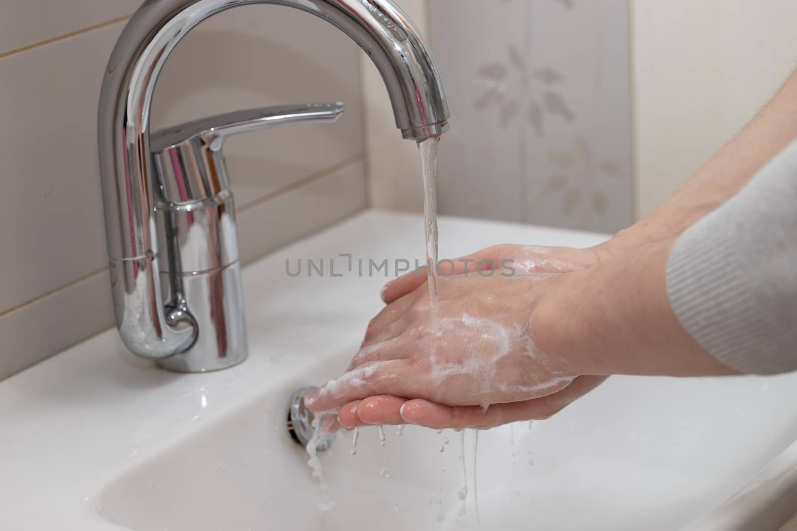 Man washing hands with soap and lathering suds. Protect against the coronavirus. Coronavirus pandemic protection by washing hands frequently. Hygiene to stop spreading coronavirus.