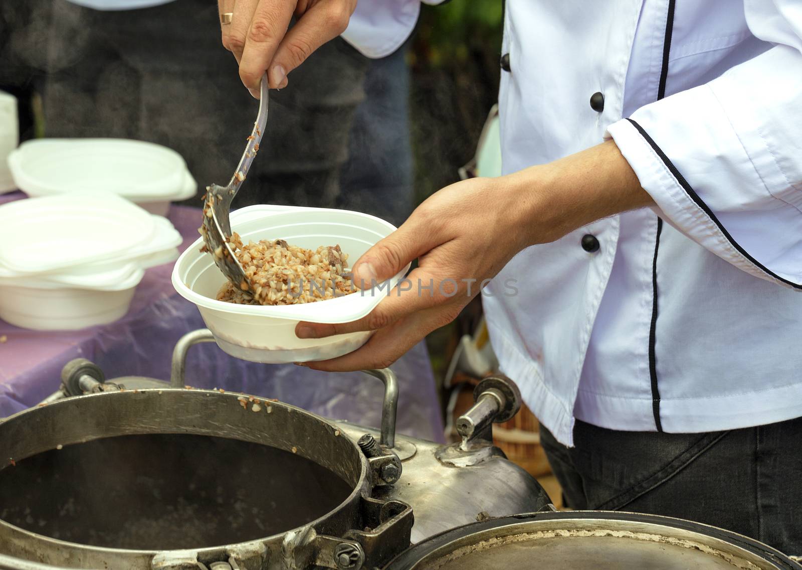 The concept of caring for the poor and the elderly: social workers feed people buckwheat porridge on the street.