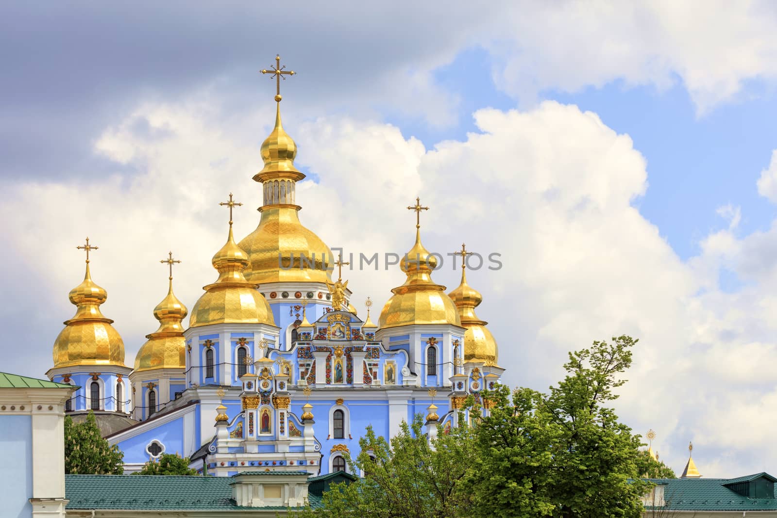 The famous Golden-domed Michael's Cathedral in Kyiv in the spring against the blue cloudy sky by Sergii