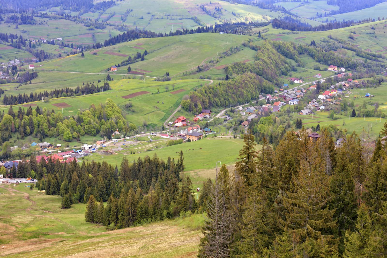 The winding roads of the Carpathian Mountains pass through cozy villages in the valley.