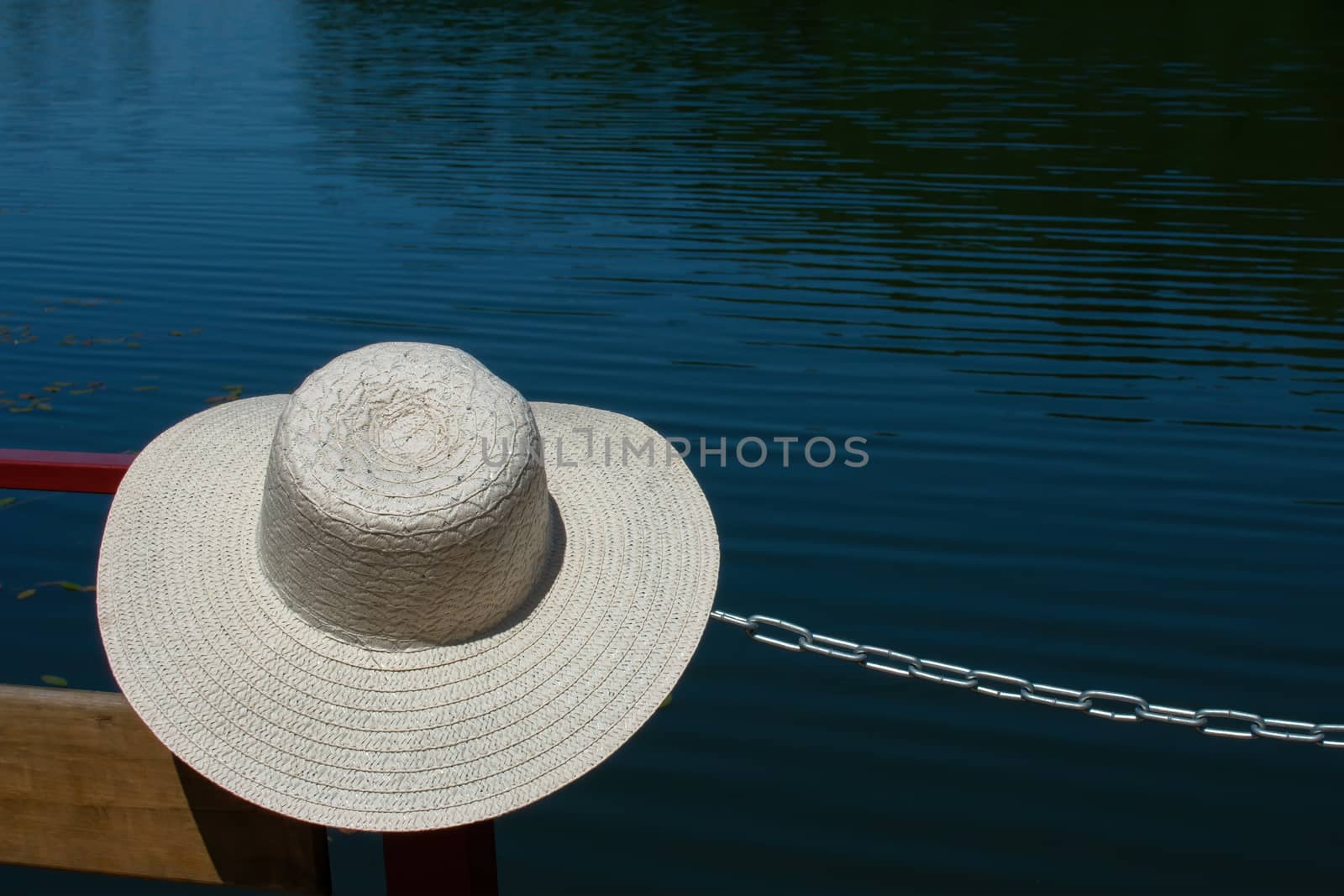 Summer holiday banner. Beach accessory-a straw hat, on a blue turquoise background of water. Vacation travel concept