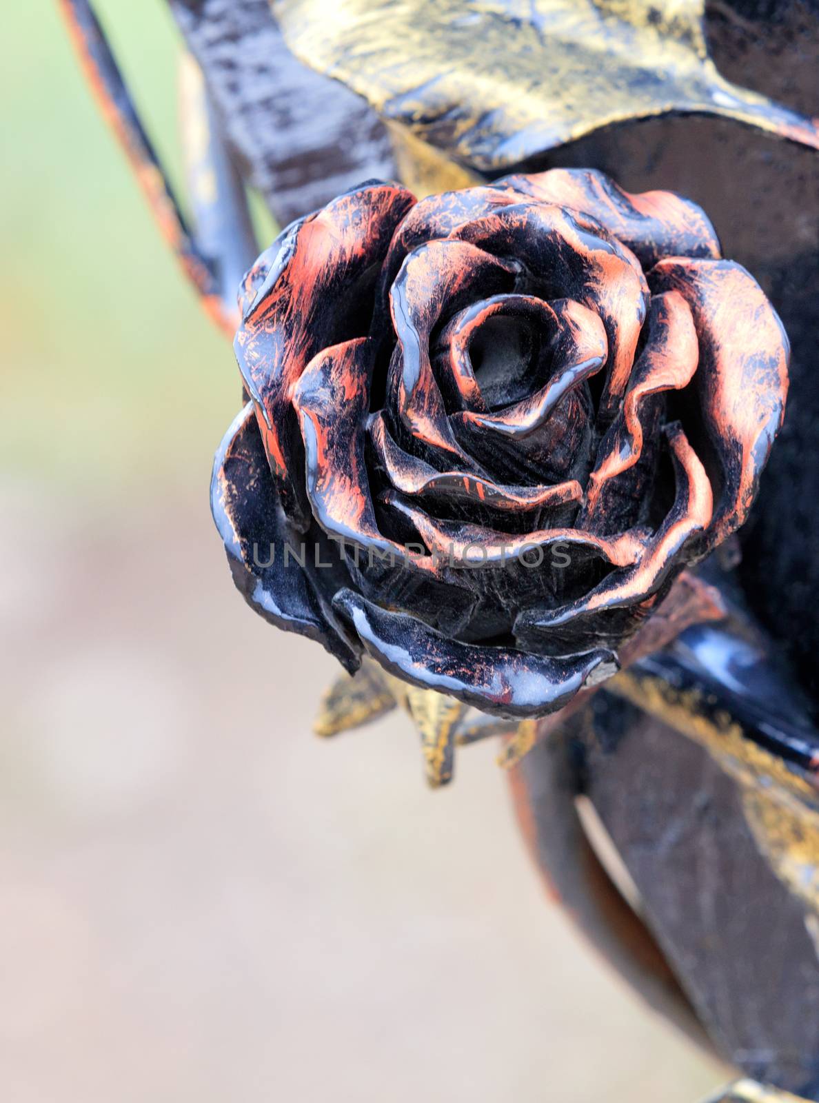 Red rose wrought iron and bronze, close-up with copy space.