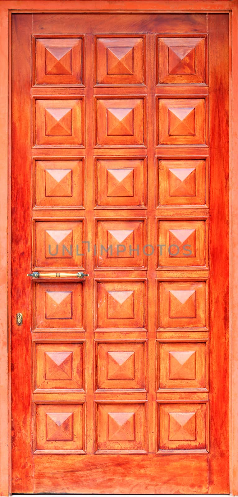 Old orange wooden entrance doors with a bronze handle and symmetrical square panels in Greek style. by Sergii