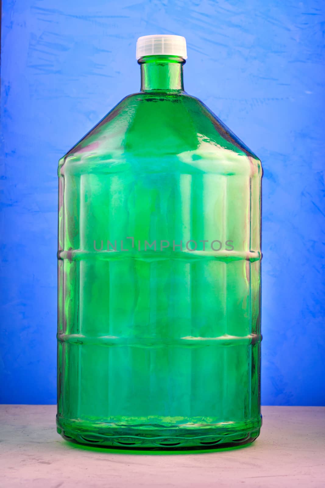 A 22 liter glass jar is made of thick green glass, image on a blue background. by Sergii