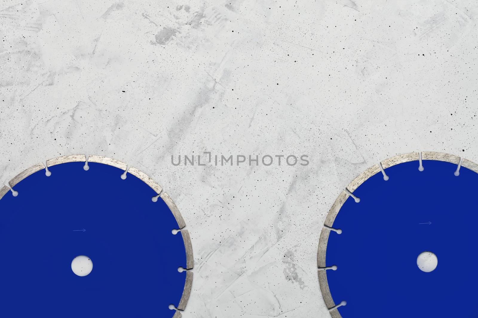 Blue cutting blades with diamond for cutting concrete and reinforced concrete using an angle grinder on a gray concrete background, image with copy space.